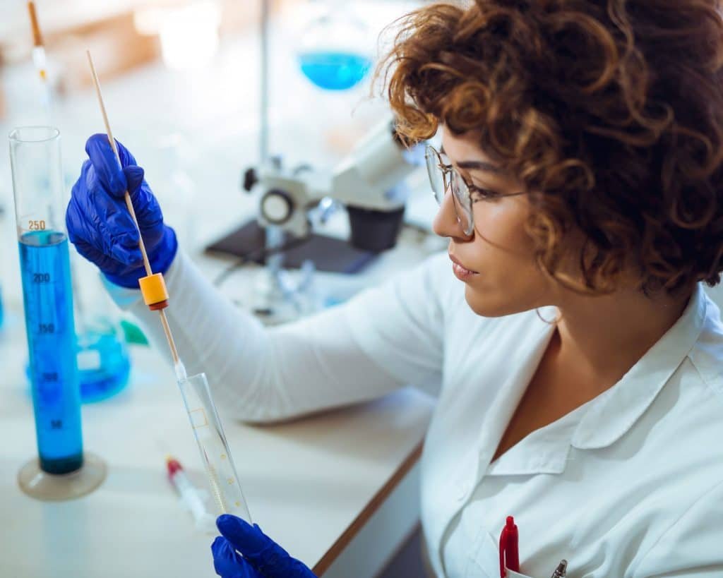 Tipos de evidencias en criminalística: Guía esencial para comprender su importancia 3 Agente de policía científica recogiendo muestras de adn en laboratorio, tipos de evidencias en criminalística