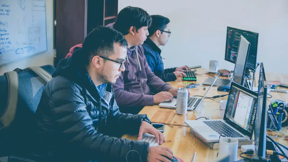 Ciberdefensa: qué es, funciones y salidas profesionales 4 Especialistas informáticos trabajan juntos frente a ordenadores y monitores